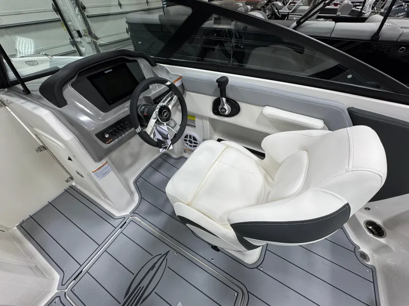 Slide: The Image of 2025 Chaparral 21 SSi boat interior with steering wheel and white captain's chair. - 2