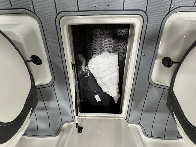 Slide: The Image of 2025 Chaparral 21 SSi boat storage compartment with items inside. - 21