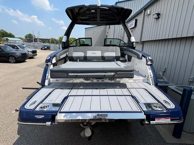 Slide: The Image of 2026 Chaparral SSX 6 boat with open deck, parked outdoors near a building. - 16