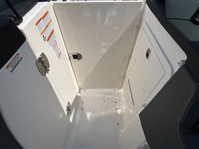 Slide: The Image of Interior view of 2026 Chaparral SSX 6 boat compartment with storage and safety labels. - 37