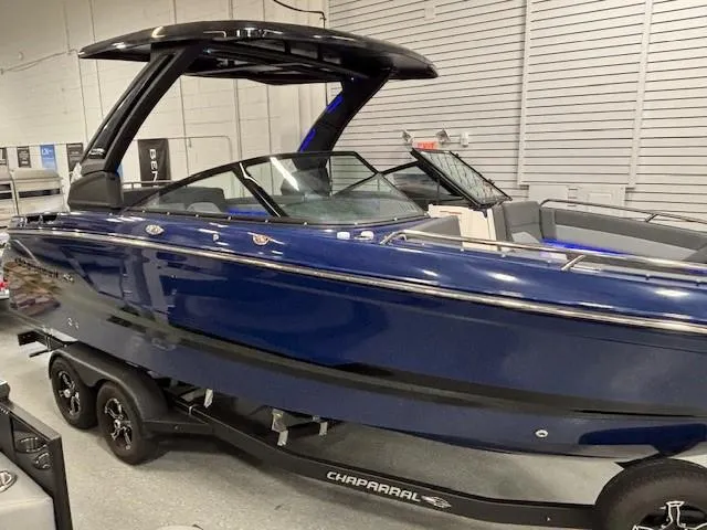Slide: The Image of 2026 Chaparral SSX 6 boat in showroom, sleek blue design on trailer. - 49