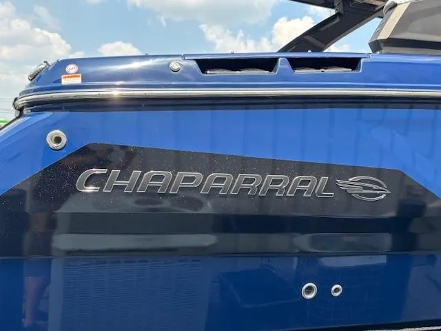 Slide: The Image of 2026 Chaparral SSX 6 boat, blue exterior with logo, under a clear sky. - 51