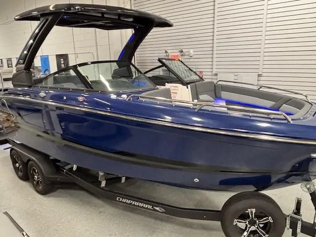 Slide: The Image of 2026 Chaparral SSX 6 boat in showroom, sleek blue design on trailer. - 7