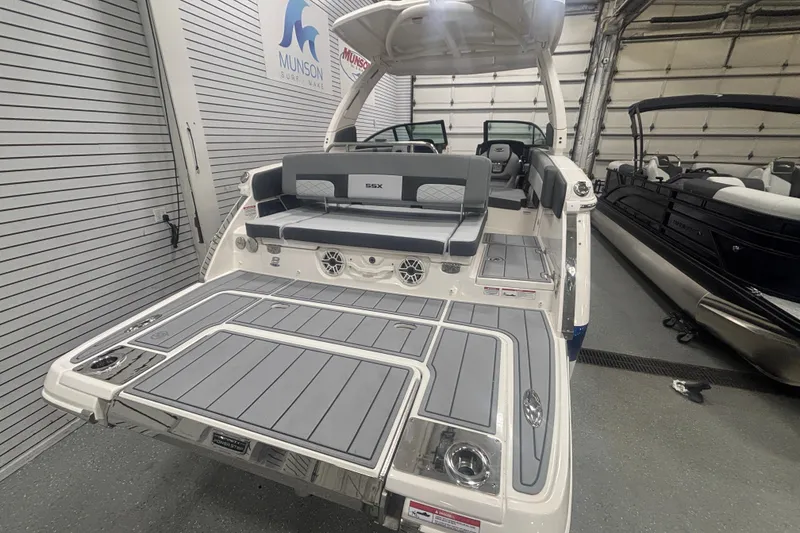 Slide: The Image of 2026 Chaparral 8 SSX boat with sleek design and spacious seating in a showroom. - 19