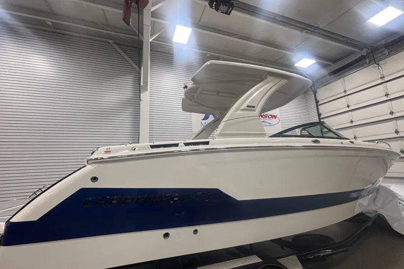 Slide: The Image of 2026 Chaparral 8 SSX boat in showroom, white and blue design, sleek and modern. - 4