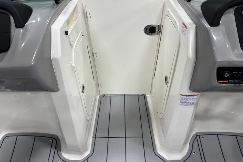 Slide: The Image of 2026 Chaparral 23 SSi boat interior with gray flooring and white storage compartments. - 17