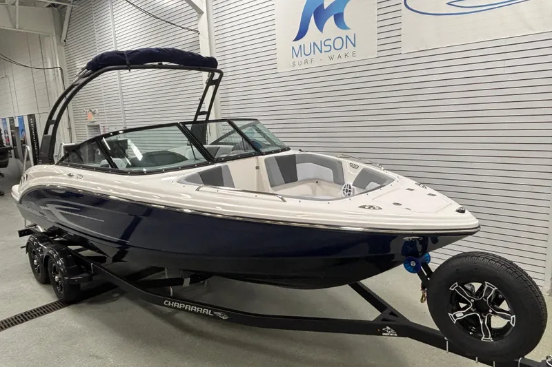 Slide: The Image of 2026 Chaparral 23 SSi boat on trailer in showroom, Munson Surf Wake signage visible. - 2