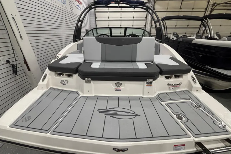 Slide: The Image of 2026 Chaparral 23 SSi boat with sleek gray seating and deck, showcased indoors. - 29