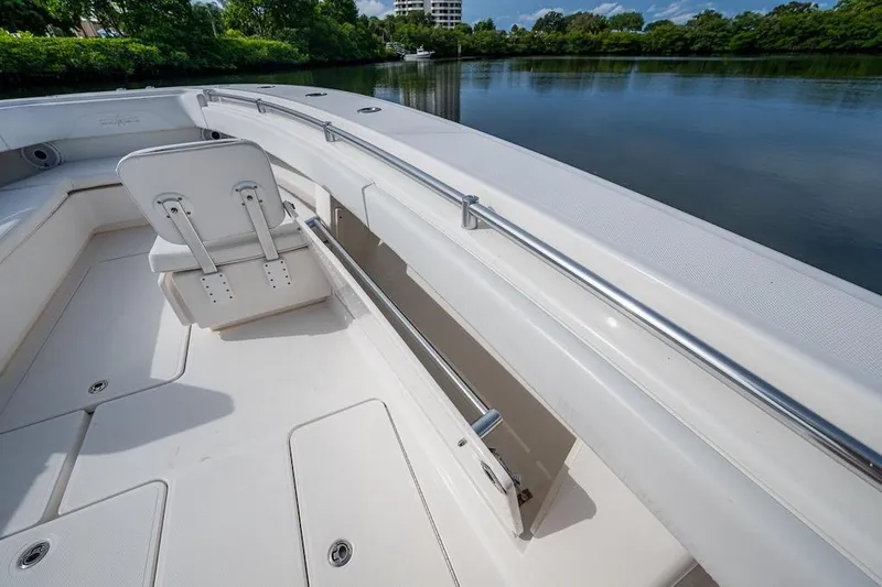 Slide: The Image of 2016 Invincible 39 Open Fisherman boat interior with seating and storage, docked by a serene lake. - 13