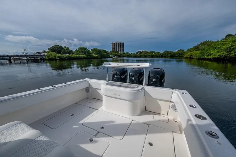 Slide: The Image of 2016 Invincible 39 Open Fisherman boat on calm water, featuring triple outboard engines. - 14