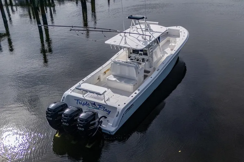 Slide: The Image of 2016 Invincible 39 Open Fisherman boat with triple engines on calm water. - 2