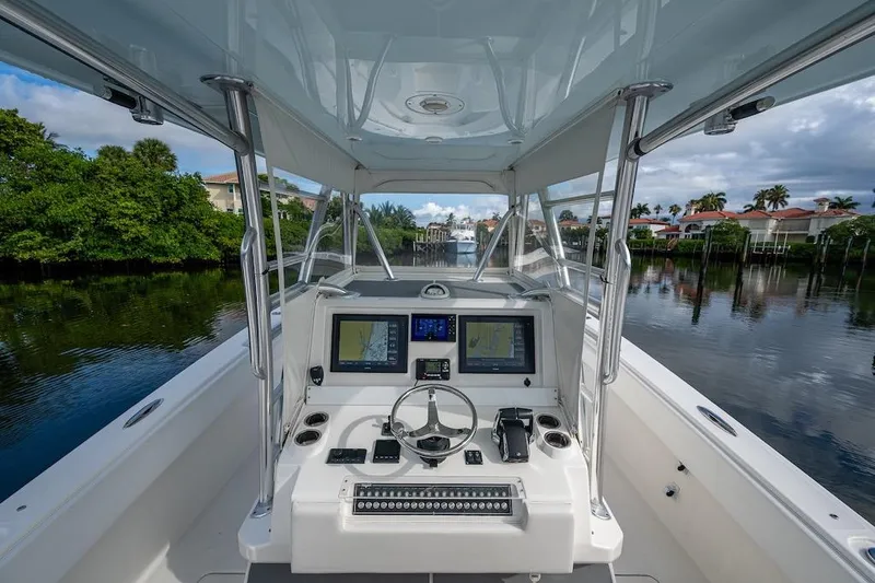 Slide: The Image of 2016 Invincible 39 Open Fisherman boat cockpit with navigation screens and steering wheel. - 27