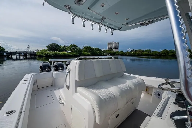 Slide: The Image of 2016 Invincible 39 Open Fisherman boat on calm water, featuring spacious seating and dual engines. - 28