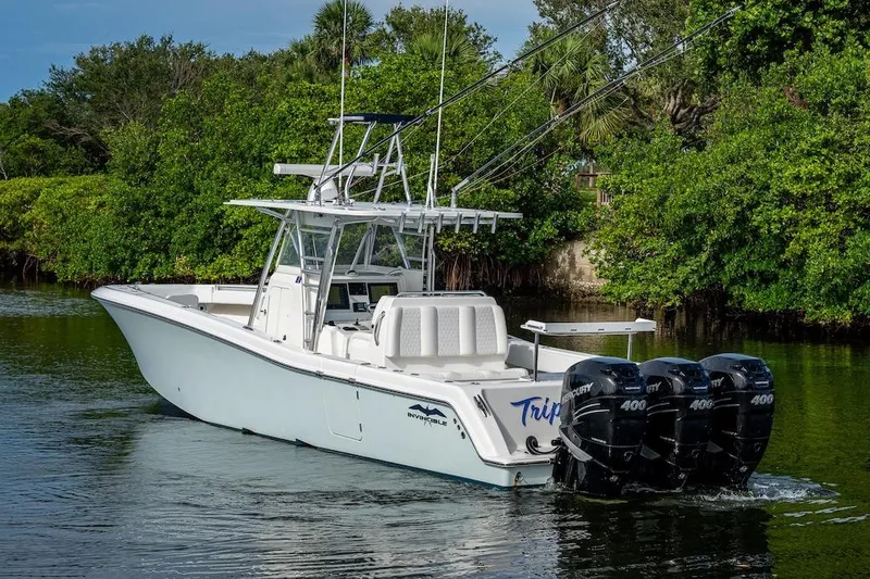 Slide: The Image of 2016 Invincible 39 Open Fisherman boat with triple Mercury 400 engines on a calm waterway. - 34