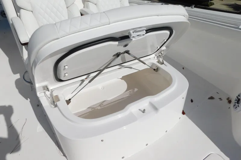 Slide: The Image of Open storage compartment on 2026 Regulator 30XO boat with white cushioned seating. - 15