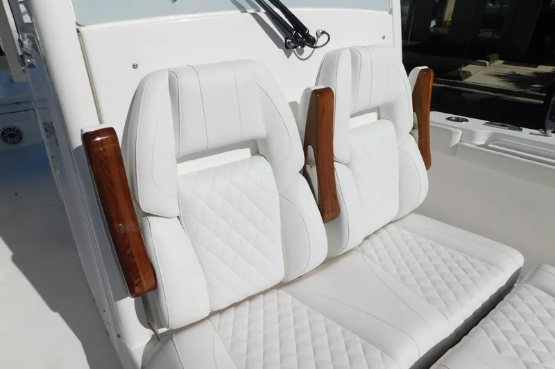 Slide: The Image of 2026 Regulator 30XO boat with luxurious white leather seating and wooden armrests. - 16
