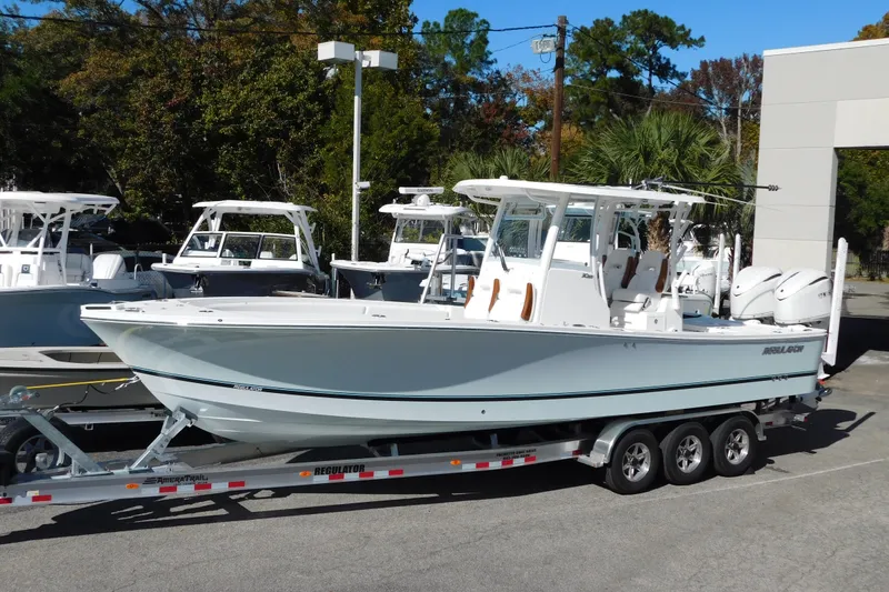 Slide: The Image of 2026 Regulator 30XO boat on trailer, displayed outdoors with other boats. - 4