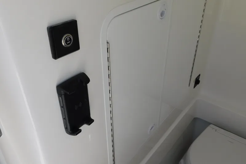 Slide: The Image of Interior of 2026 Regulator 30XO boat featuring light switch and storage compartment. - 49