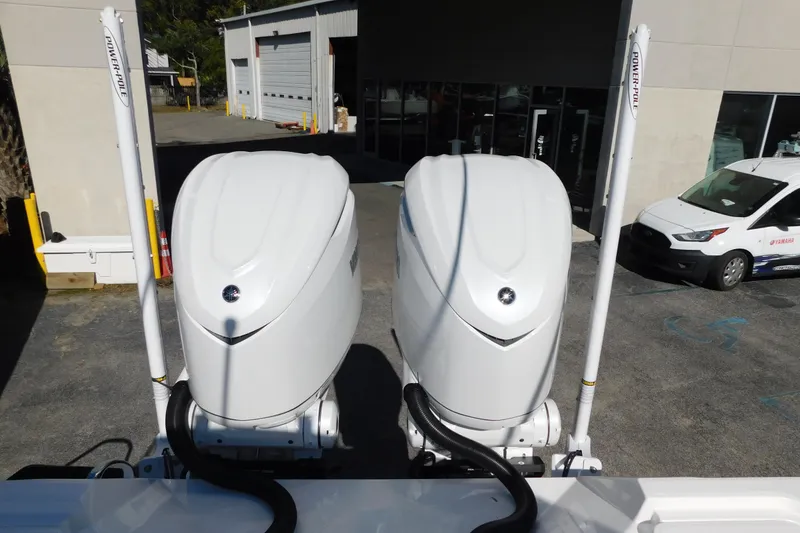 Slide: The Image of Twin outboard engines on a 2026 Regulator 30XO boat, parked near a service center. - 54