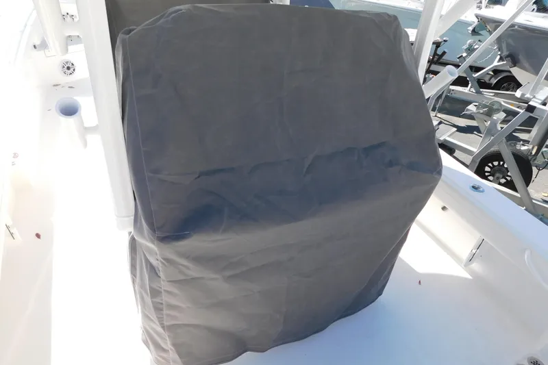 Slide: The Image of Covered console on a 2026 Regulator 30XO boat, docked with visible equipment. - 56