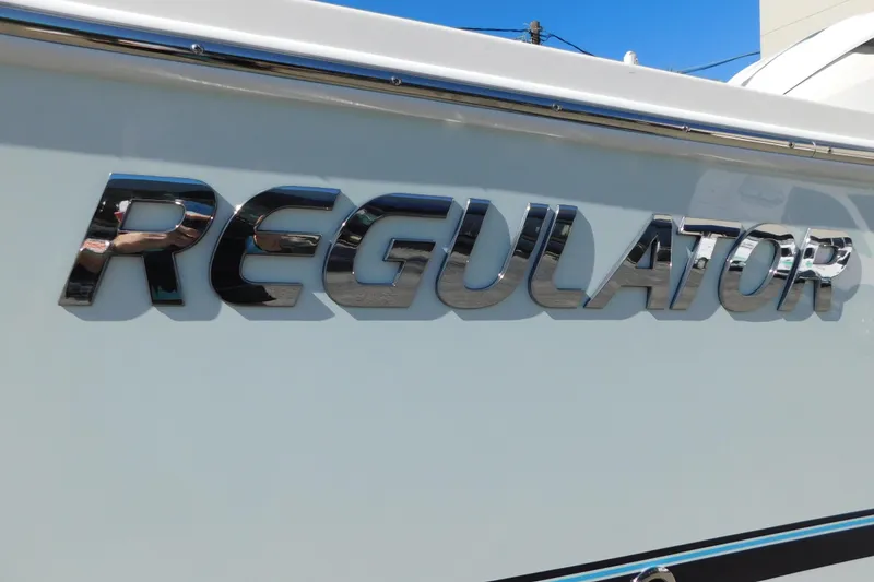 Slide: The Image of 2026 Regulator 30XO boat logo in shiny chrome lettering on white hull. - 64