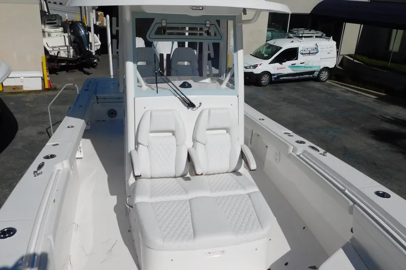 Slide: The Image of 2026 Regulator 30XO boat with white seating and console, parked outdoors. - 9