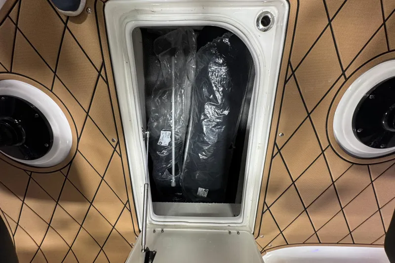 Slide: The Image of Storage compartment in 2026 Chaparral 6 SSX boat with tan diamond-patterned interior. - 28