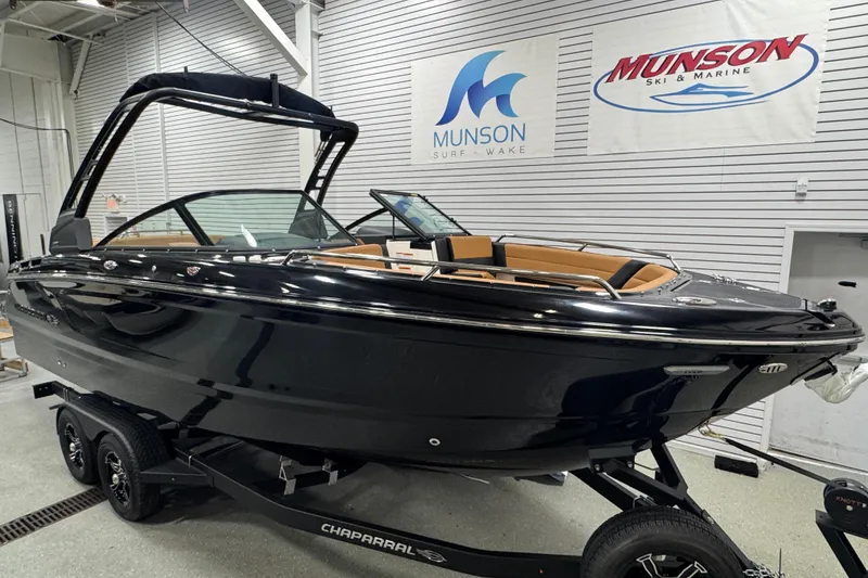 Slide: The Image of 2026 Chaparral 6 SSX boat in showroom, black exterior, on trailer, Munson Ski & Marine signage. - 3