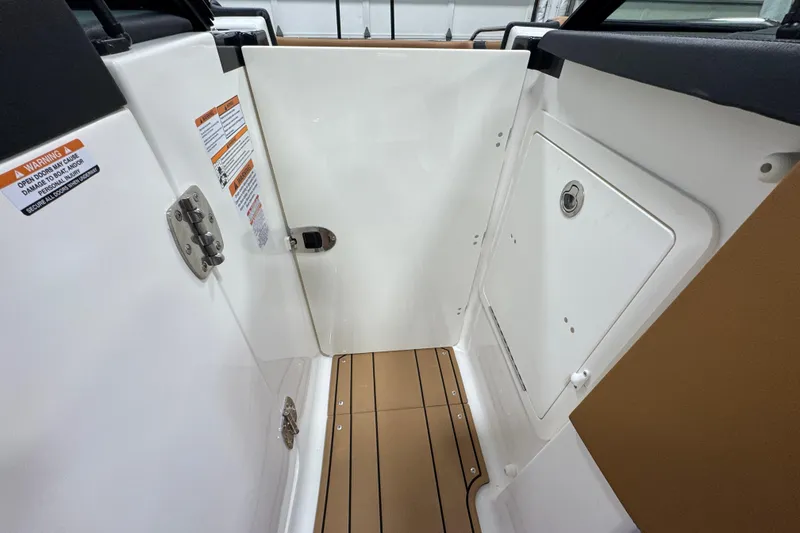 Slide: The Image of Interior view of 2026 Chaparral 6 SSX boat, featuring sleek white panels and wood-textured flooring. - 39