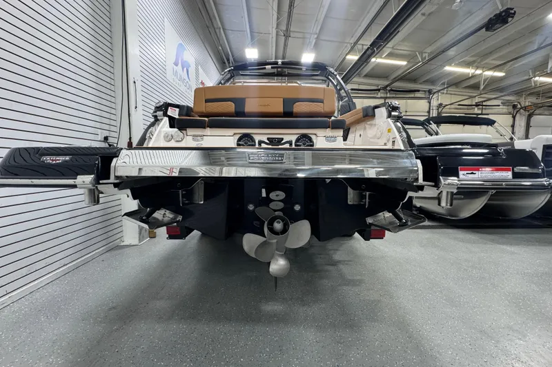 Slide: The Image of 2026 Chaparral 6 SSX boat in showroom, rear view with propeller and seating. - 5