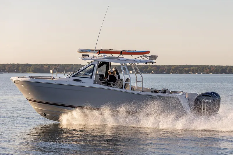 Slide: The Image of Manufacturer Provided Image: 2025 Solara S-310 CW boat cruising on a calm lake at sunset. - 9