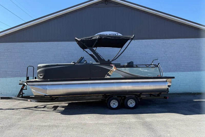 The Image of 2026 Avalon 2385 LSZ VRB pontoon boat with windshield on trailer, parked outdoors. - 1