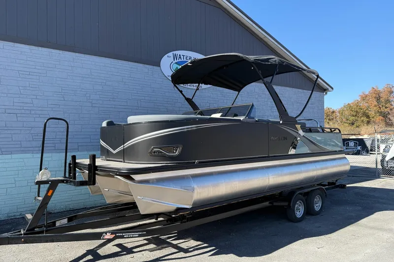 Slide: The Image of 2026 Avalon 2385 LSZ VRB Windshield pontoon boat on trailer, parked outdoors. - 2
