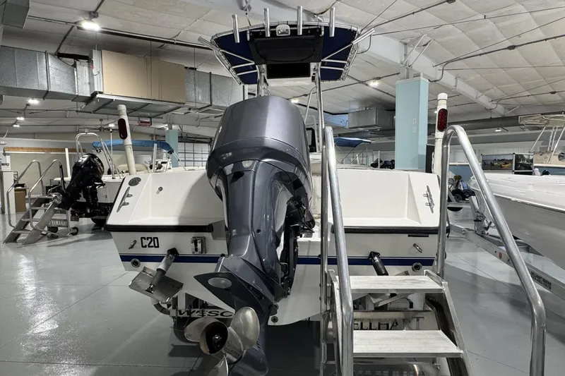 Slide: The Image of 2009 Contender 21 Open boat with outboard motor in indoor showroom. - 2