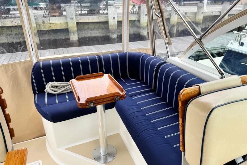 Slide: The Image of 2005 Hunt SurfHunter boat interior with blue striped seating and wooden table. - 4