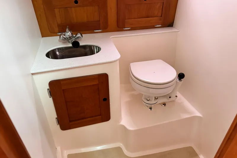 Slide: The Image of Compact boat bathroom with sink, toilet, and wooden cabinetry in a 2005 Hunt SurfHunter. - 7