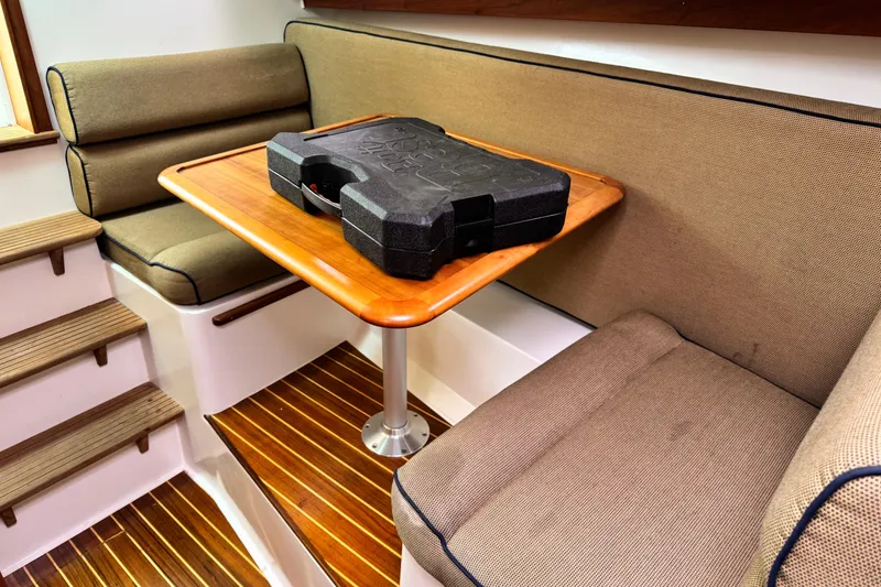 Slide: The Image of Cozy interior of 2005 Hunt SurfHunter with cushioned seating and wooden table. - 8