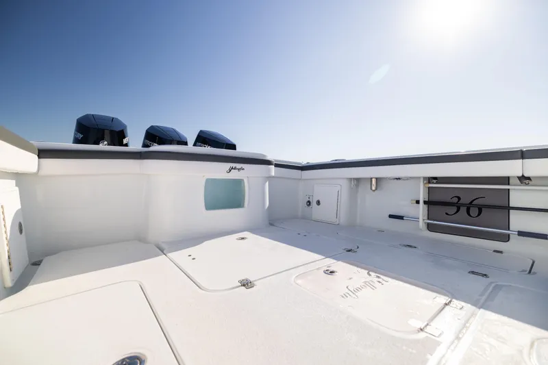 Slide: The Image of 2023 Yellowfin 36 Offshore boat deck with triple Mercury engines under clear sky. - 29