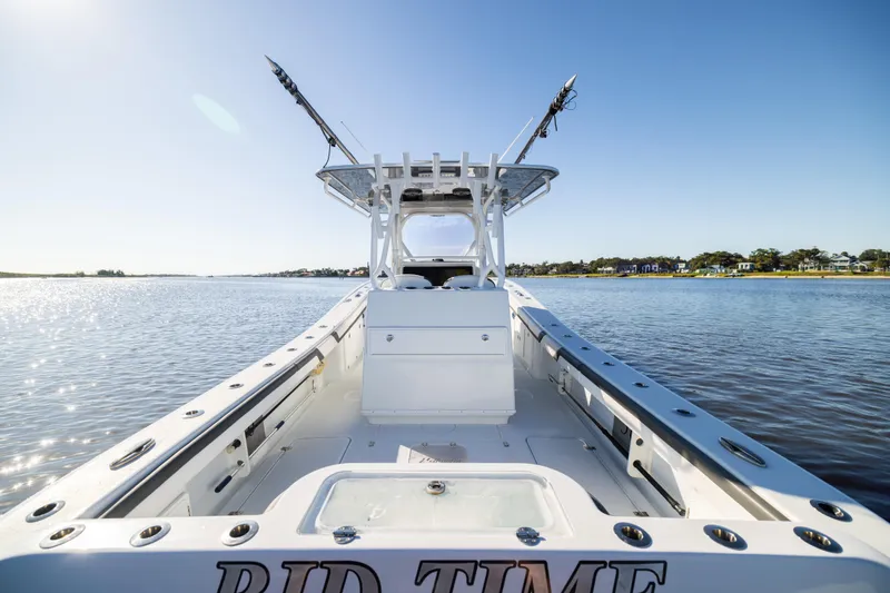 Slide: The Image of 2023 Yellowfin 36 Offshore boat on calm water, clear sky, fishing rods visible. - 32