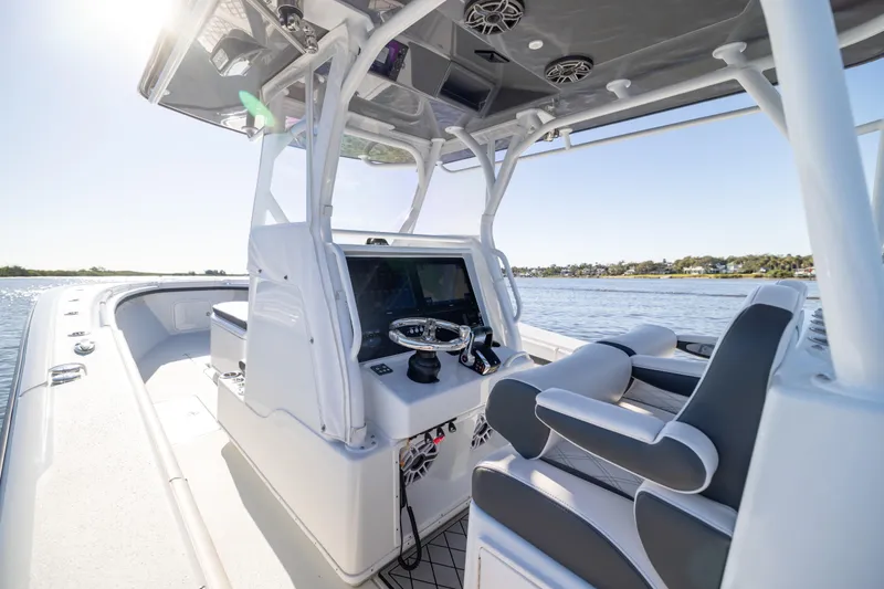Slide: The Image of 2023 Yellowfin 36 Offshore boat interior with modern helm and seating on calm water. - 38