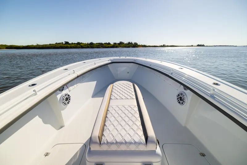 Slide: The Image of 2023 Yellowfin 36 Offshore boat interior with cushioned seating, on calm water. - 48