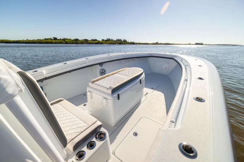 Slide: The Image of 2023 Yellowfin 36 Offshore boat interior with seating and storage, on calm water. - 49