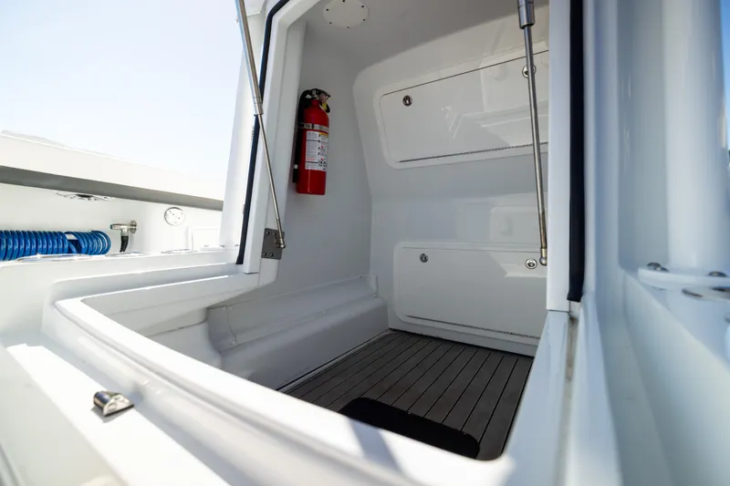 Slide: The Image of Interior view of 2023 Yellowfin 36 Offshore boat, featuring storage compartments and a fire extinguisher. - 53