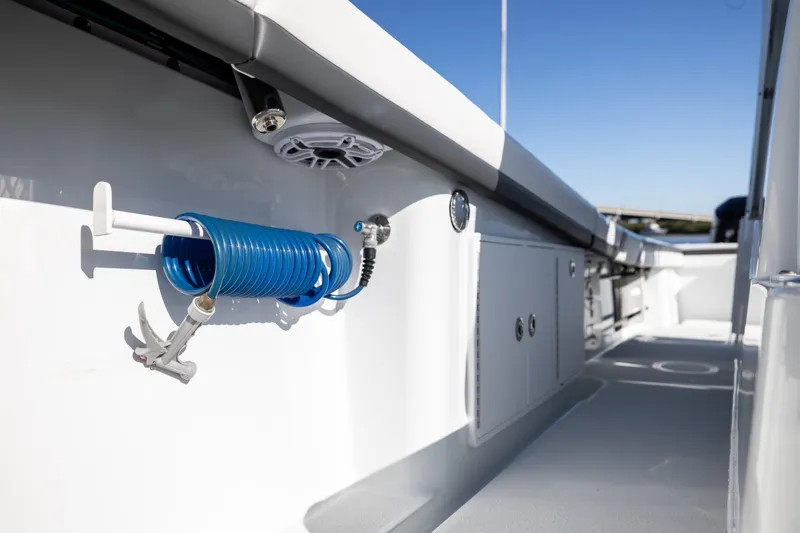 Slide: The Image of 2023 Yellowfin 36 Offshore boat deck with coiled blue hose and storage compartments. - 55