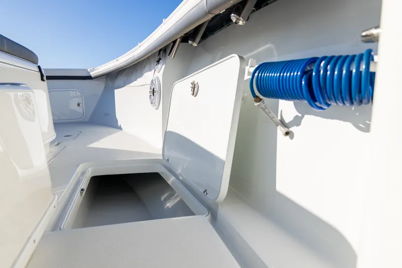 Slide: The Image of 2023 Yellowfin 36 Offshore boat interior with storage compartments and coiled hose. - 59