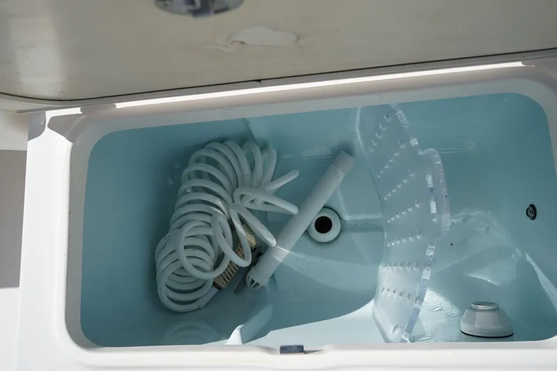 Slide: The Image of Storage compartment with coiled hose in 2023 Robalo 266 Cayman boat. - 10