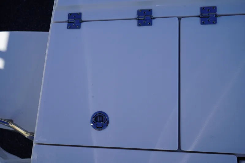 Slide: The Image of 2023 Robalo 266 Cayman boat deck with storage compartment and metal hinges. - 12