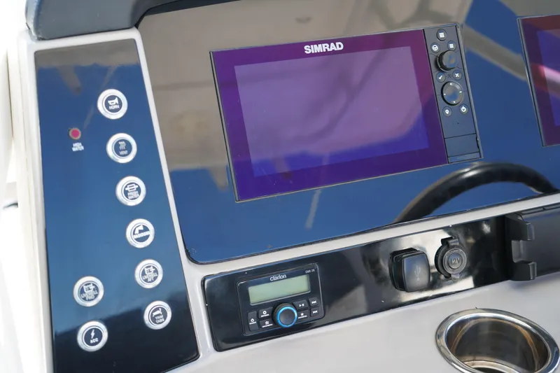 Slide: The Image of 2023 Robalo 266 Cayman dashboard with Simrad displays and control panel. - 26