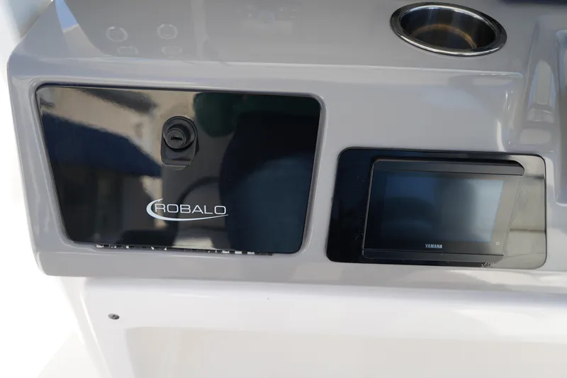 Slide: The Image of 2023 Robalo 266 Cayman dashboard with Yamaha display and storage compartment. - 28