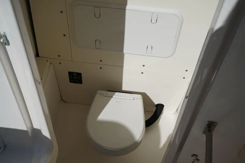 Slide: The Image of 2023 Robalo 266 Cayman boat interior with compact marine toilet. - 32